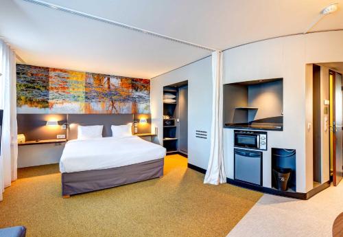 a hotel room with a bed and a kitchen at B&B HOME Rueil-Malmaison Gare in Rueil-Malmaison