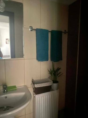 a bathroom with a sink and two blue towels at ArMA URBAN LIVING in Bendevís