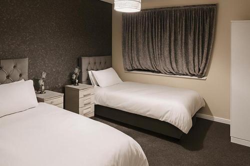a bedroom with two beds and a window at House-Sleeps 5 person -Etihad Stadium 15 min drive in Ashton under Lyne