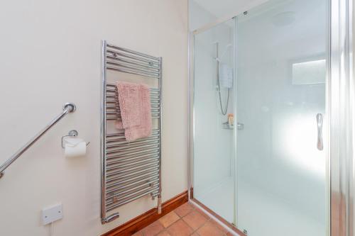 a bathroom with a shower and a glass shower stall at Willow Cottage in North Lydbury