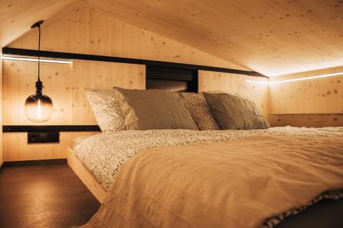 a bedroom with a bed in a room with wooden walls at Rusty Cabin -Tiny House in Neustift an der Lafnitz