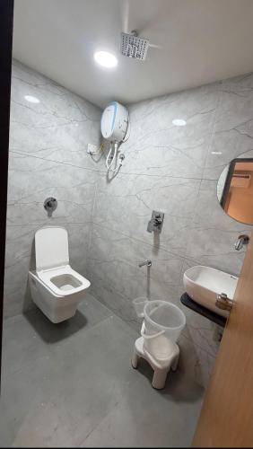 a bathroom with a toilet and a sink at Hotel Belleview VASTRAPUR in Jāmb
