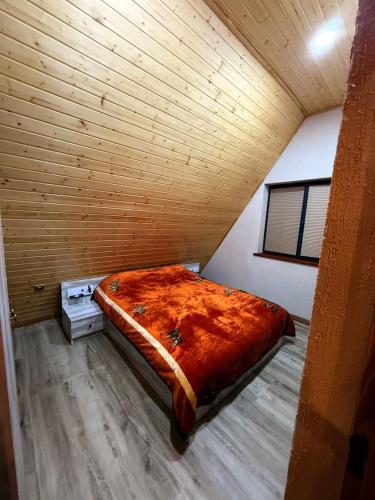a large bed in a room with a wooden ceiling at A-frame , Quba Qecres in Qǝçrǝş