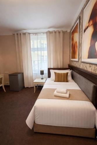 a bedroom with a large bed and a window at Royal Rooms Self Check-in in Poznań