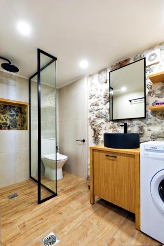 a bathroom with a sink and a washing machine at Mirthia Apartments in Myrthios