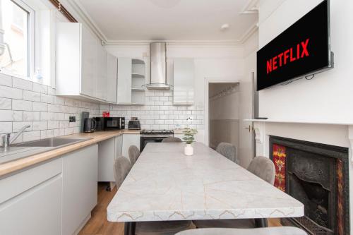 a white kitchen with a table and a fireplace at The Haven Lodge in Gillingham