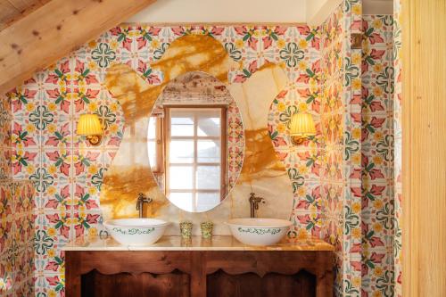 a bathroom with two sinks and a mirror at Hôtel Saint-Georges Relais & Châteaux in Megève