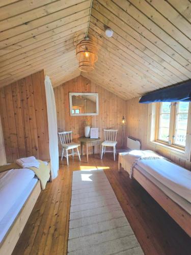 a bedroom with two beds and a table and chairs at Kyrkjestølen B&B in Tyinkrysset