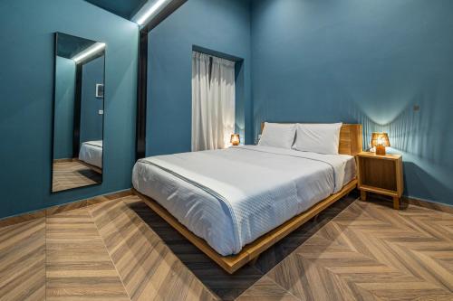 a blue bedroom with a bed and a mirror at Iliotropio Athens, Thisio in Athens