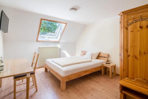 a bedroom with a bed and a desk and a window at WG-Pension in Landshut