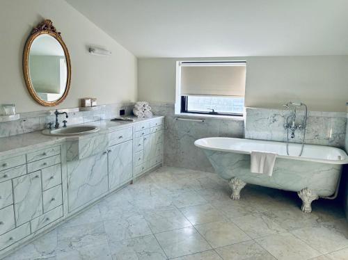 a bathroom with a tub and a sink and a mirror at Kursaal Hotel in Cattolica