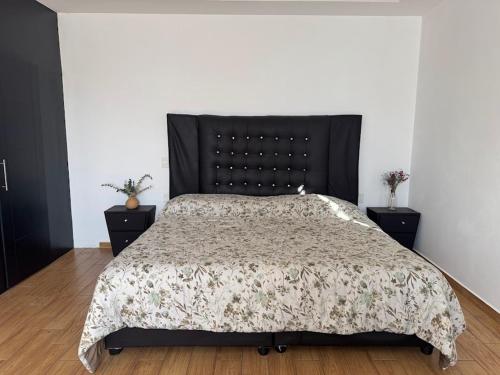 a bedroom with a large bed with a black headboard at Casa Terraza Oaxaca in San Sebastián Etla