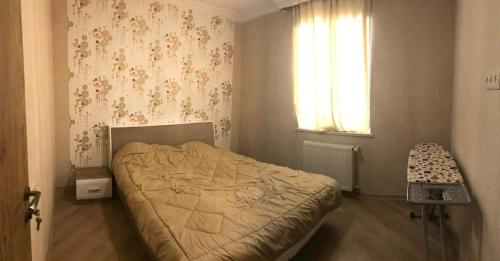 a bedroom with a bed and a window and a chair at mtatsminda residence in Itʼkhvisi