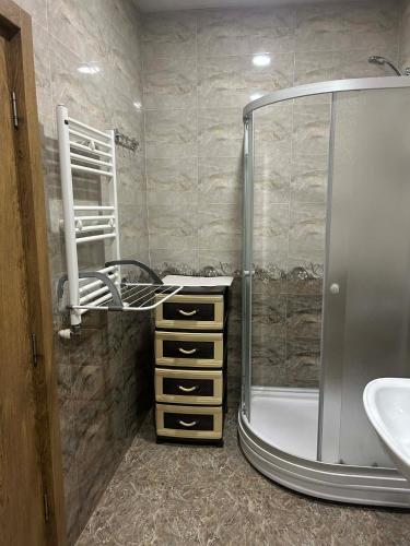 a bathroom with a shower and a sink at mtatsminda residence in Itʼkhvisi