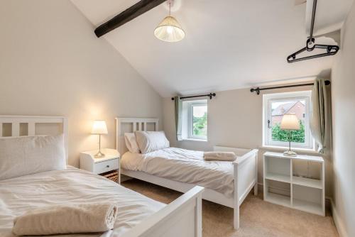 a bedroom with two beds and two windows at 3 Bed in Alfrick oc-s32386 in Broadwas