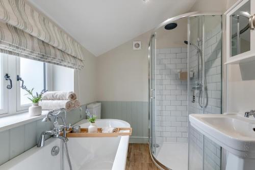 a bathroom with a tub and a sink and a shower at 3 Bed in Alfrick oc-s32386 in Broadwas