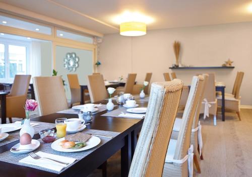 ein Esszimmer mit einem langen Tisch und Stühlen in der Unterkunft Hotel Ancora Timmendorfer Strand, Pool inklusive in Timmendorfer Strand