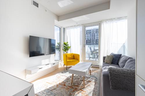 a living room with a couch and a tv at Luxury Apartments with View & Indoor Heated Pool in Montréal