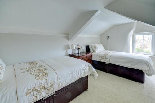 a white bedroom with two beds and a window at 4 Bed in Parracombe oc-laurel in Parracombe