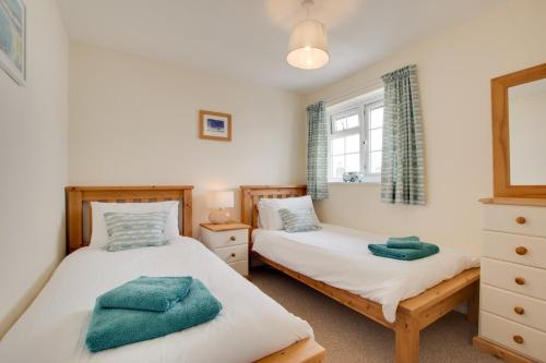 a bedroom with two beds and a window at 2 Bed in Instow oc-stones in Instow