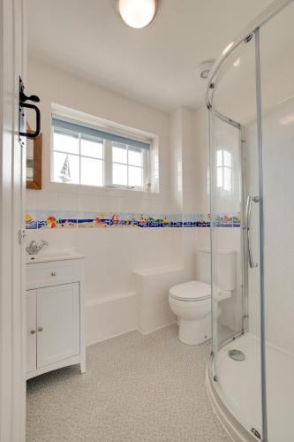 a bathroom with a shower and a toilet and a sink at 2 Bed in Instow oc-stones in Instow