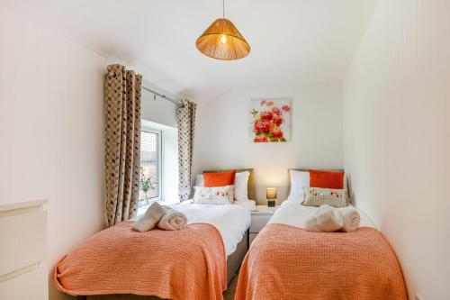 a bedroom with two beds with orange sheets and a window at 2 Bed in Neenton oc-s29533 in Neenton
