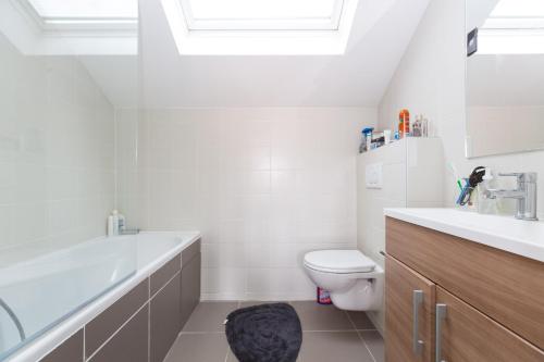 une salle de bain blanche avec des toilettes et un lavabo dans l'établissement Stunning And Luxurious 3BR Loft 5min From Paris In The Heart Of Boulogne, à Boulogne-Billancourt