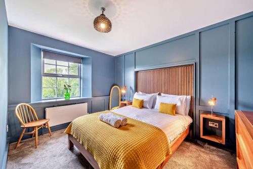a bedroom with blue walls and a bed with a yellow blanket at 4 Bed in Goodleigh oc-e29107 in Goodleigh