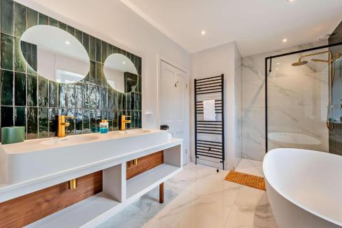 a bathroom with two sinks and a tub and a shower at 4 Bed in Goodleigh oc-e29107 in Goodleigh