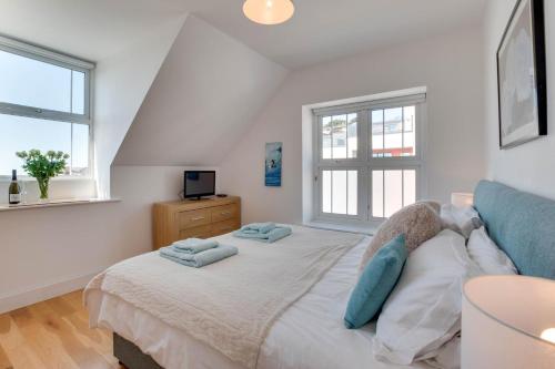 a bedroom with a bed with two towels on it at 1 Bed in Woolacombe oc-seablu in Woolacombe