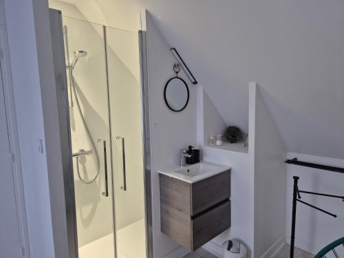 a bathroom with a glass shower and a sink at Chez Ninie in Le Cloître-Saint-Thégonnec
