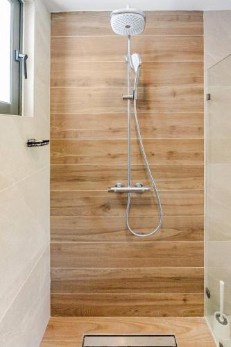 a shower in a bathroom with a wooden wall at Cana Cove in Punta Cana