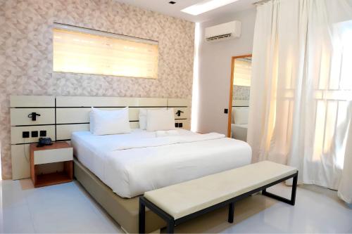 a bedroom with a large white bed and a window at 2020 Apartment Katampe in Mama