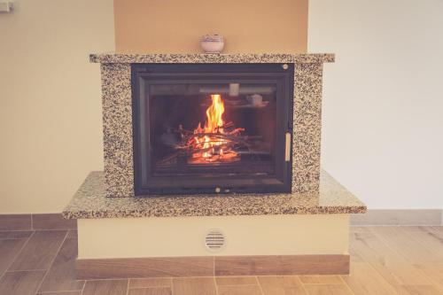 a fireplace with a fire inside of it at Elizabeta Holiday Home in Štrigova