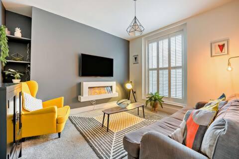 a living room with a couch and a tv at Beautiful Town Centre Apartment 110 Square Metre With Parking WEEKLY and MONTHLY Reduced Rates in Shrewsbury