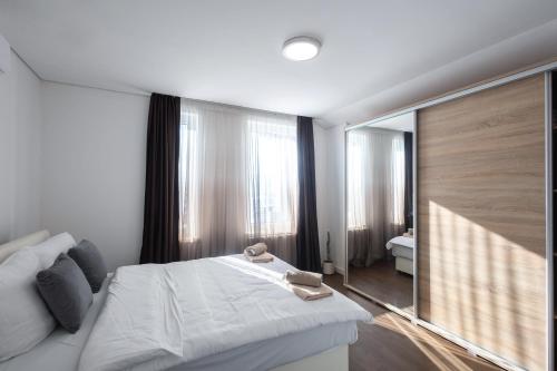 a bedroom with a white bed and a large mirror at Aeris Residence Panoramic View in Sarajevo