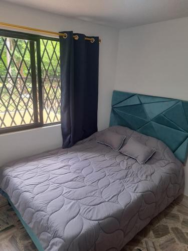 a bed in a room with a large window at Hotel Casa Franco in Cali