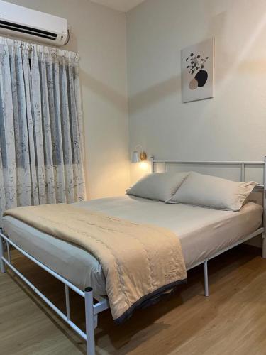 a large bed in a bedroom with a window at Desa Ibol Cottage and River - Max 10Pax in Kampong Sumpitan