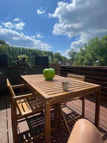 une table en bois avec une pomme posée sur une terrasse dans l'établissement Apartment Design Suite, à Jehanster