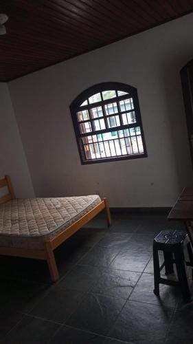 a room with a bed and a window at casa de praia grande e espaçosa in Bertioga