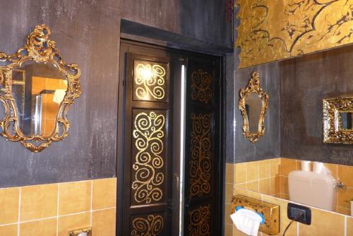a bathroom with a black door and gold mirrors at - SOTTO Le STELLE - B&B in Caltabellotta