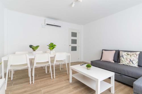 a living room with a table and chairs and a couch at Hauzify I Apartament Pedrera in Tarragona