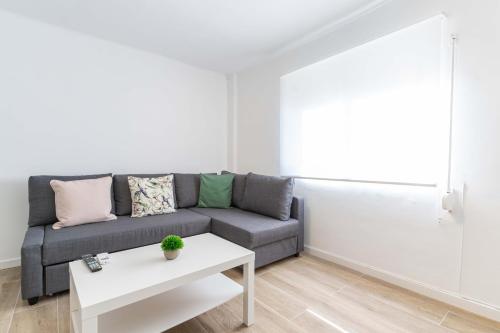 a living room with a couch and a table at Hauzify I Apartament Pedrera in Tarragona