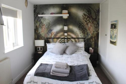 a bedroom with a bed with a painting on the wall at Hornby Cottage in Saint Michaels on Wyre