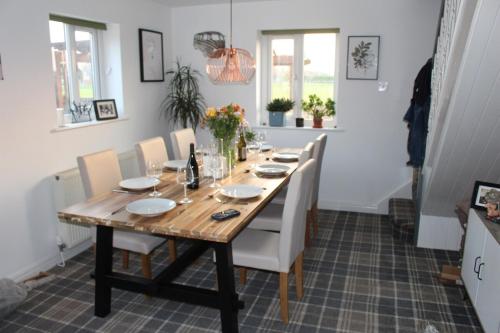 a dining room with a wooden table and chairs at Hornby Cottage in Saint Michaels on Wyre