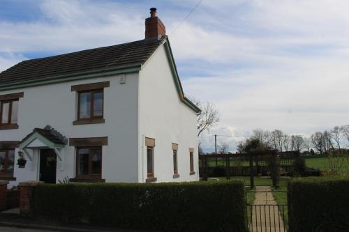 a white house with a black roof at Hornby Cottage in Saint Michaels on Wyre