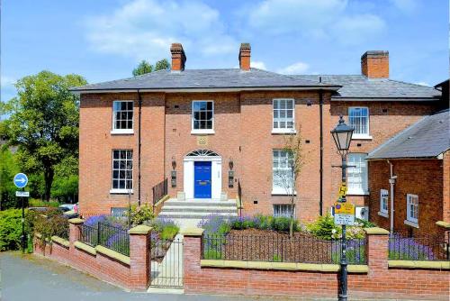a large brick house with a blue door at Beautiful Town Centre Apartment 110 Square Metre With Parking WEEKLY and MONTHLY Reduced Rates in Shrewsbury