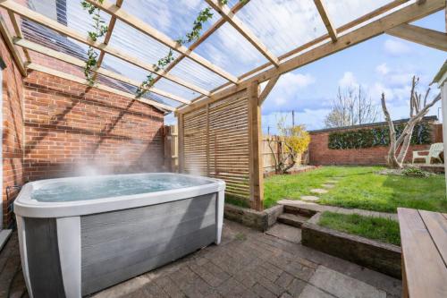 a hot tub in a garden with a pergola at 3BR Home with Hot Tub and Garden in Totton