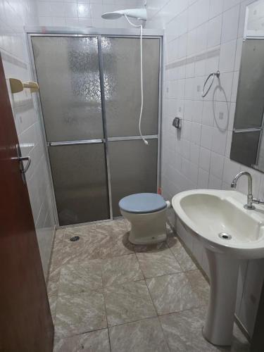 a bathroom with a shower and a toilet and a sink at casa de praia grande e espaçosa in Bertioga