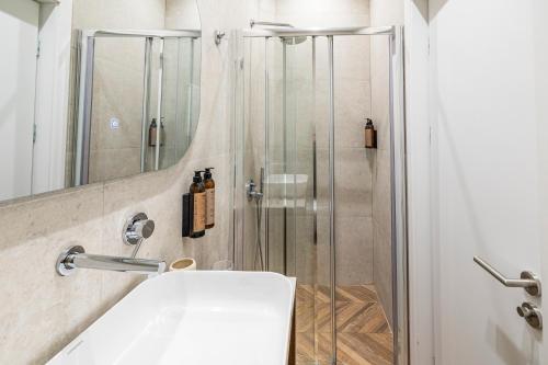 a bathroom with a shower and a white sink at Iliotropio Athens, Thisio in Athens